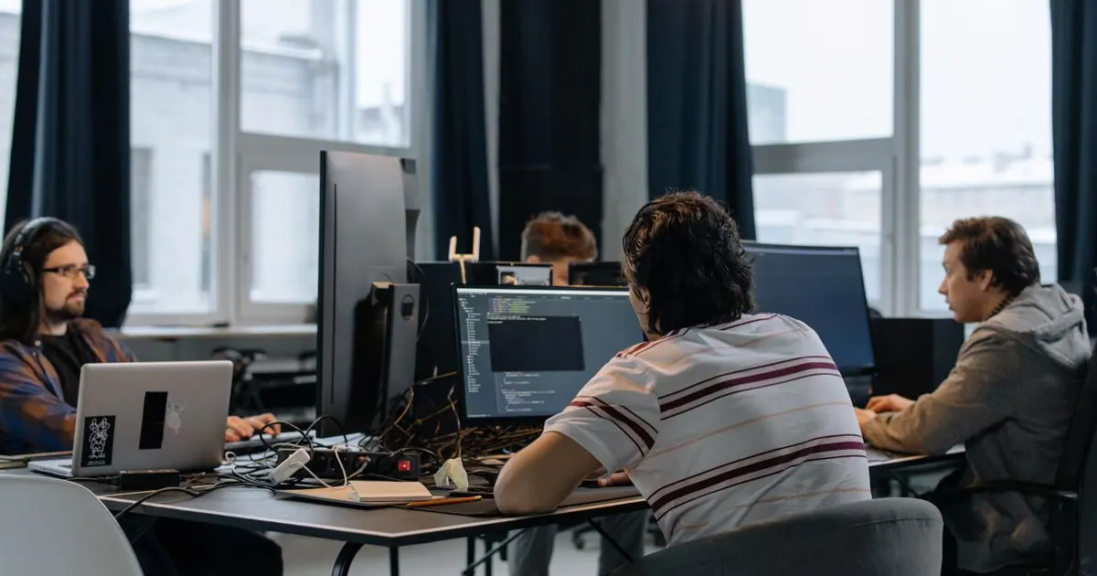 Equipe de desenvolvimento trabalhando em computadores em um escritório